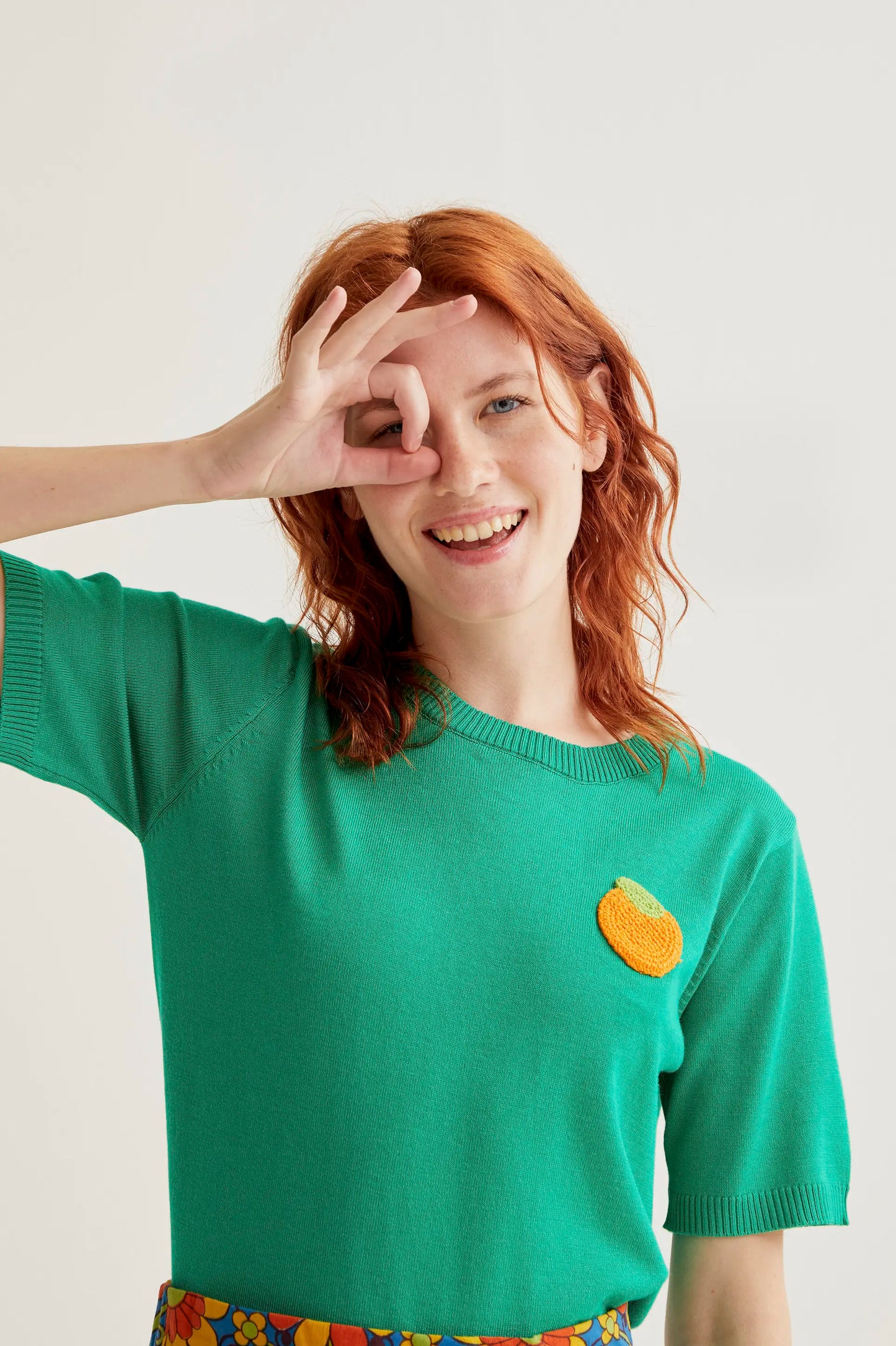 Green knit top with orange embroidery