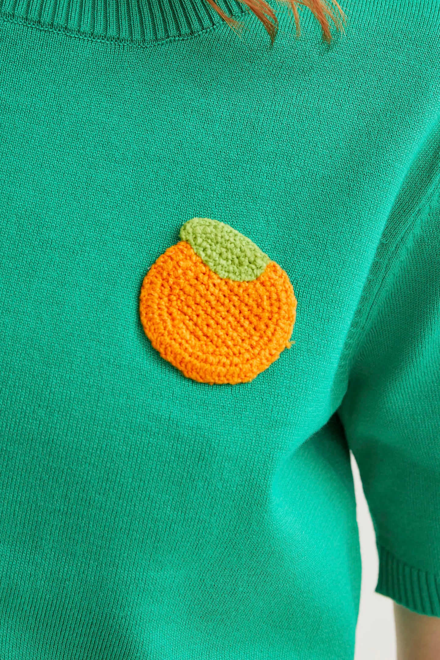 Green knit top with orange embroidery