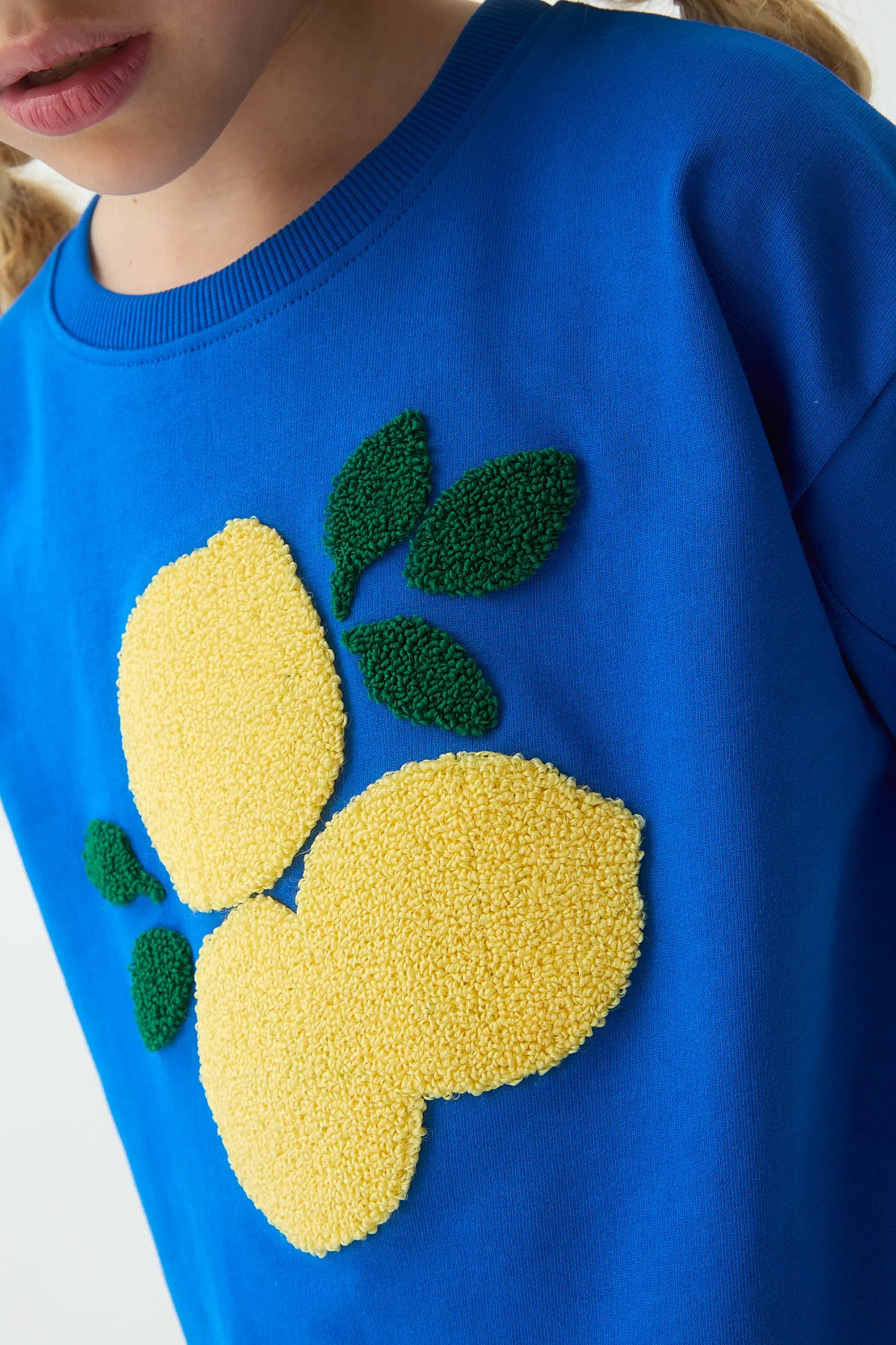 Blue girl's sweatshirt with lemon patch