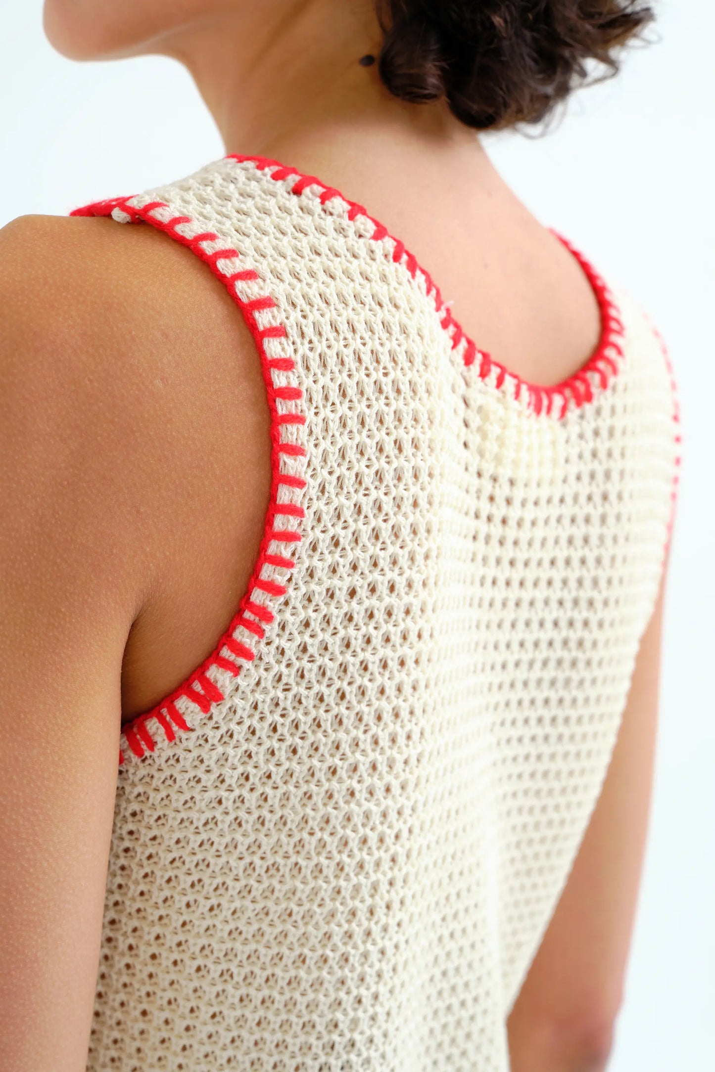 Top in maglia traforata color bianco sporco con dettagli ricamati in rosso