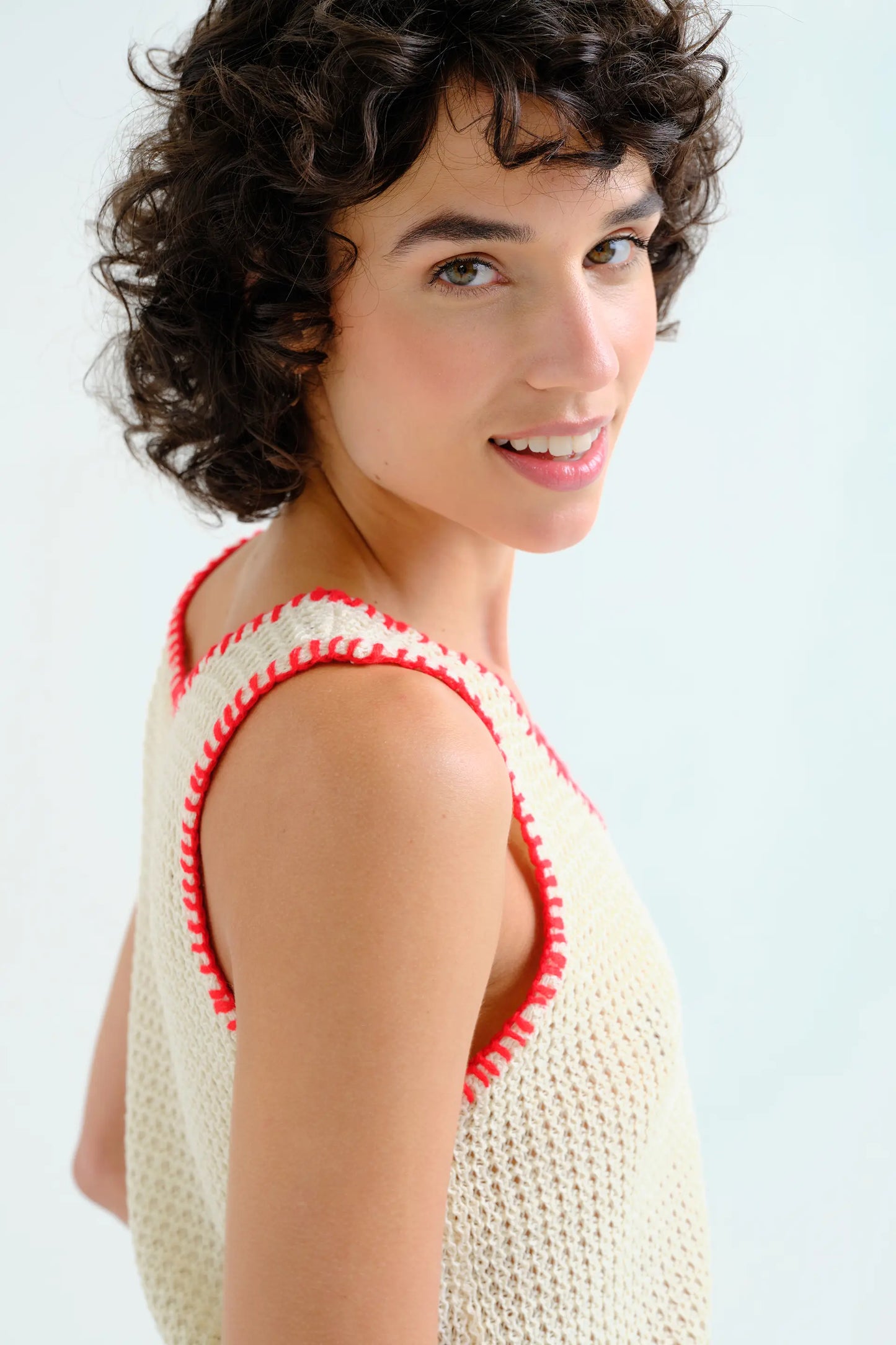 Top in maglia traforata color bianco sporco con dettagli ricamati in rosso