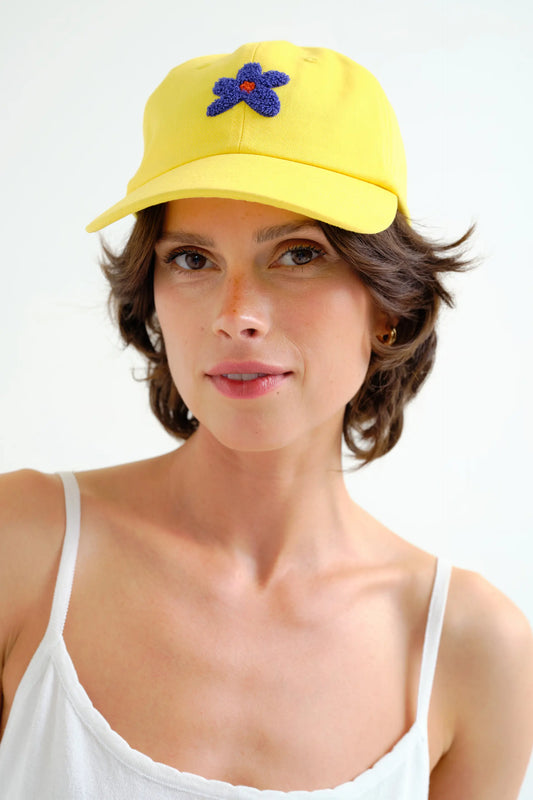 Gorra amarilla con bordado de flor azul