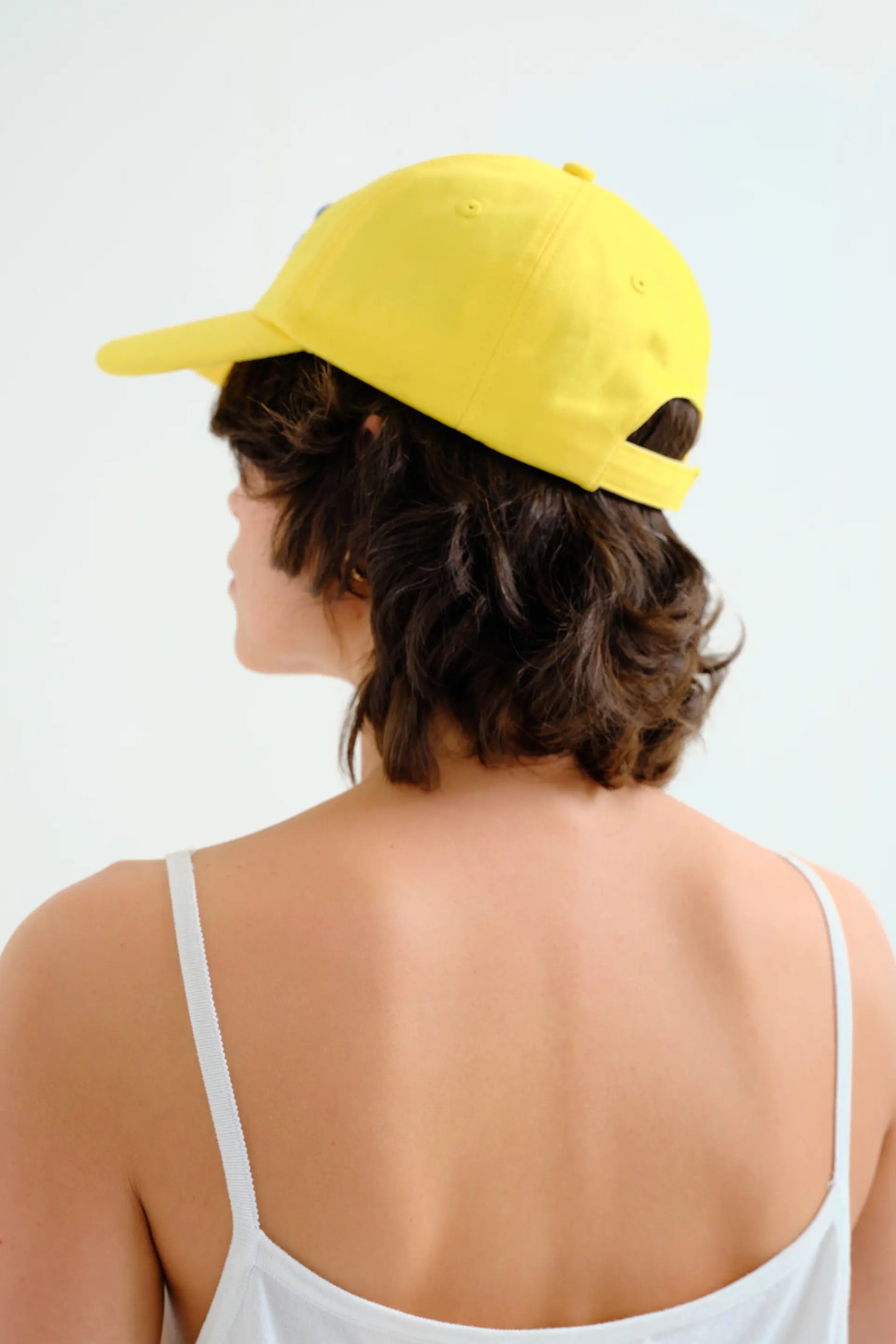 Gorra amarilla con bordado de flor azul