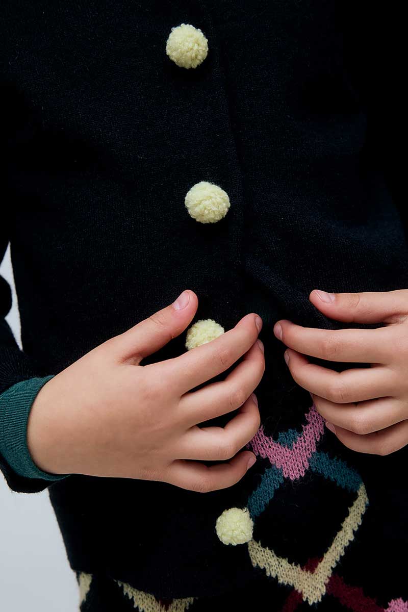 Cárdigan negro de niña negro con botones de pompones
