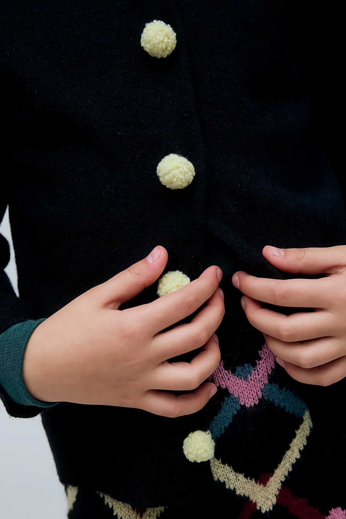 Cárdigan negro de niña negro con botones de pompones
